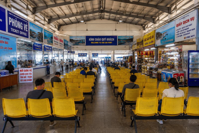 Nhà chờ bên trong cảng Cửa Đại với hàng ghế vàng và gian hàng dịch vụ hai bên